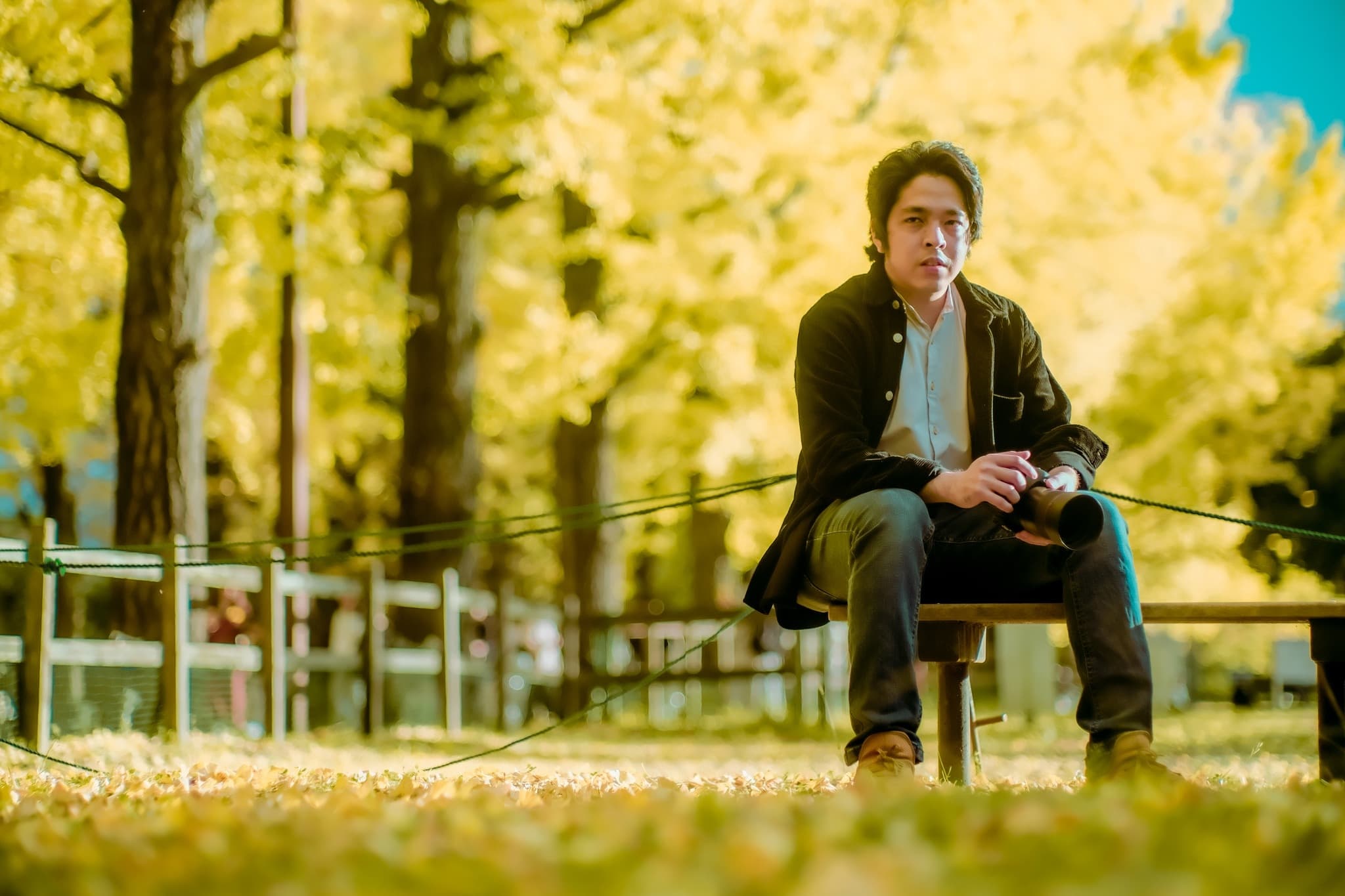 Drew — Filipino photographer in Japan, seated beneath golden ginkgo trees